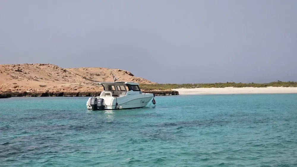 Boat anchored by the clear turquoise water of the Daymaniyat Islands